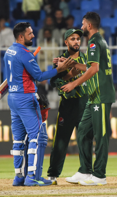 Nabi and Ihsanullah shake hands after the match